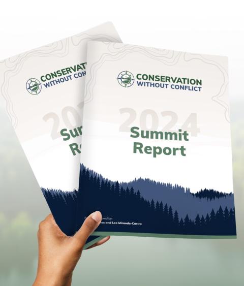 Person holding copies of the new Conservation without Conflict Summit Report