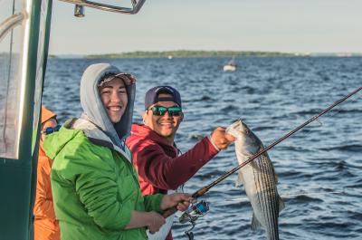 Two anglers with striped bass