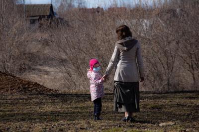 Mother and daughter outdoors wearing protective masks