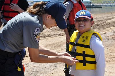 State agency staff helps with a lifejacket