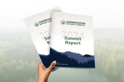 Person holding copies of the new Conservation without Conflict Summit Report