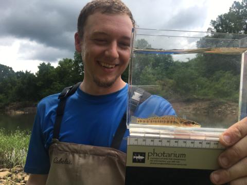 Colt Holley (MS student) with a longnose darter he captured from Lee Creek.
