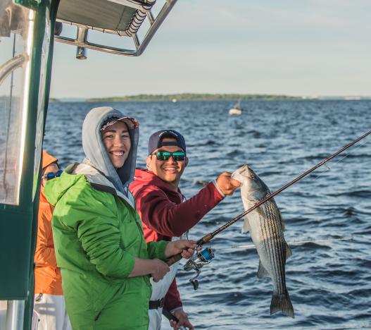 Two anglers with striped bass