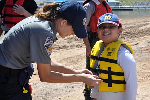 NDOW staff helps a child put on a life jacket
